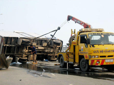 Xe tải đâm thành cầu vượt rồi lật nghiêng